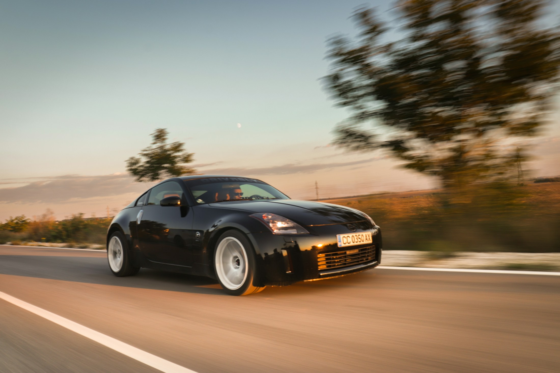 Automóvil negro en carretera al atardecer
